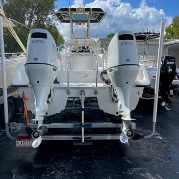 White center console fishing boat with twin outboards