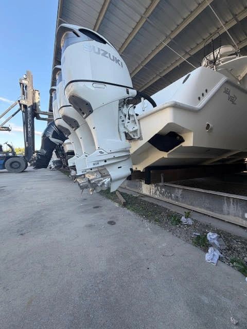 White Suzuki outboard motor on storage rack